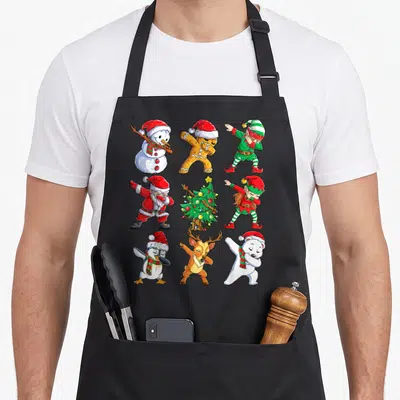 Santa christmas elf apron - Eight cartoon Christmas characters dabbing in a 3x3 grid with red and green accents — shown on a black cotton canvas apron against a white background
