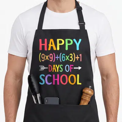 Formula school 100th teacher apron - Rainbow math equation text with white arrow pointing right on black background — shown on a black cotton canvas apron against a white background