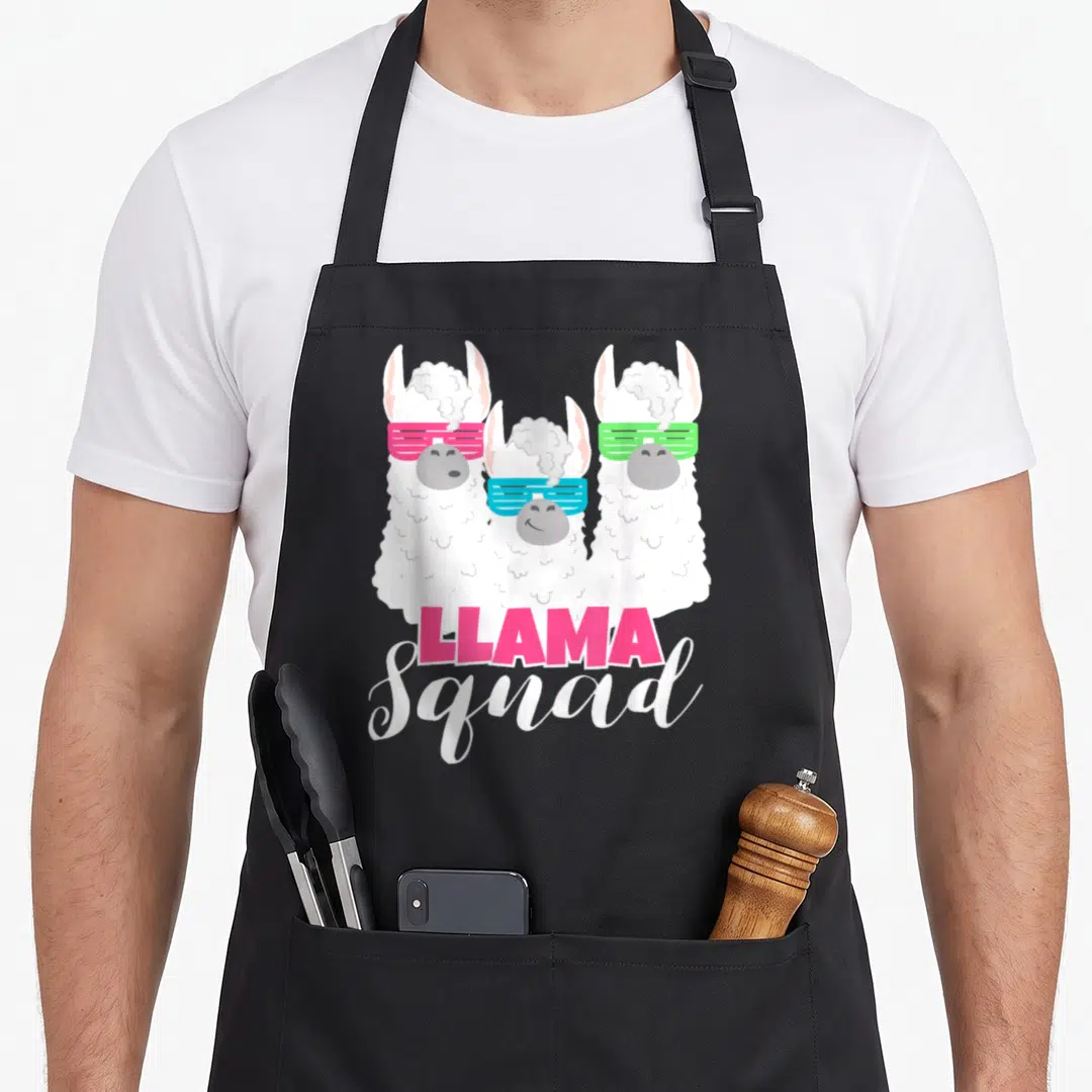 Llama 80s apron - Three cartoon llamas with pink blue and green sunglasses above pink and white stacked text — shown on a black cotton canvas apron against a white background