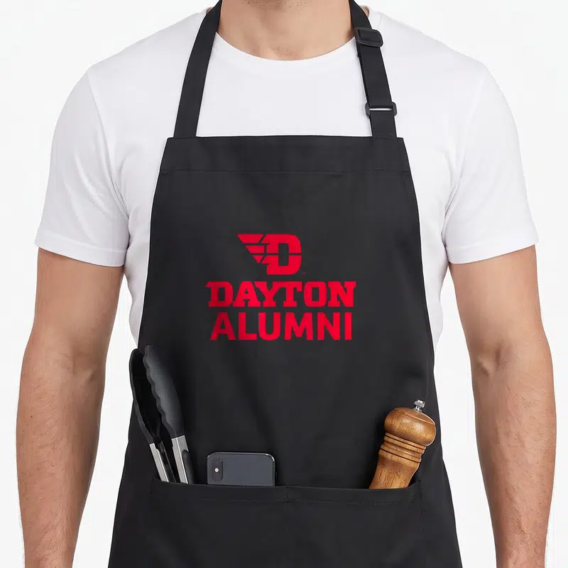 Alumni dayton apron - Red winged D logo above stacked DAYTON ALUMNI text on canvas apron — shown on a black cotton canvas apron against a white background
