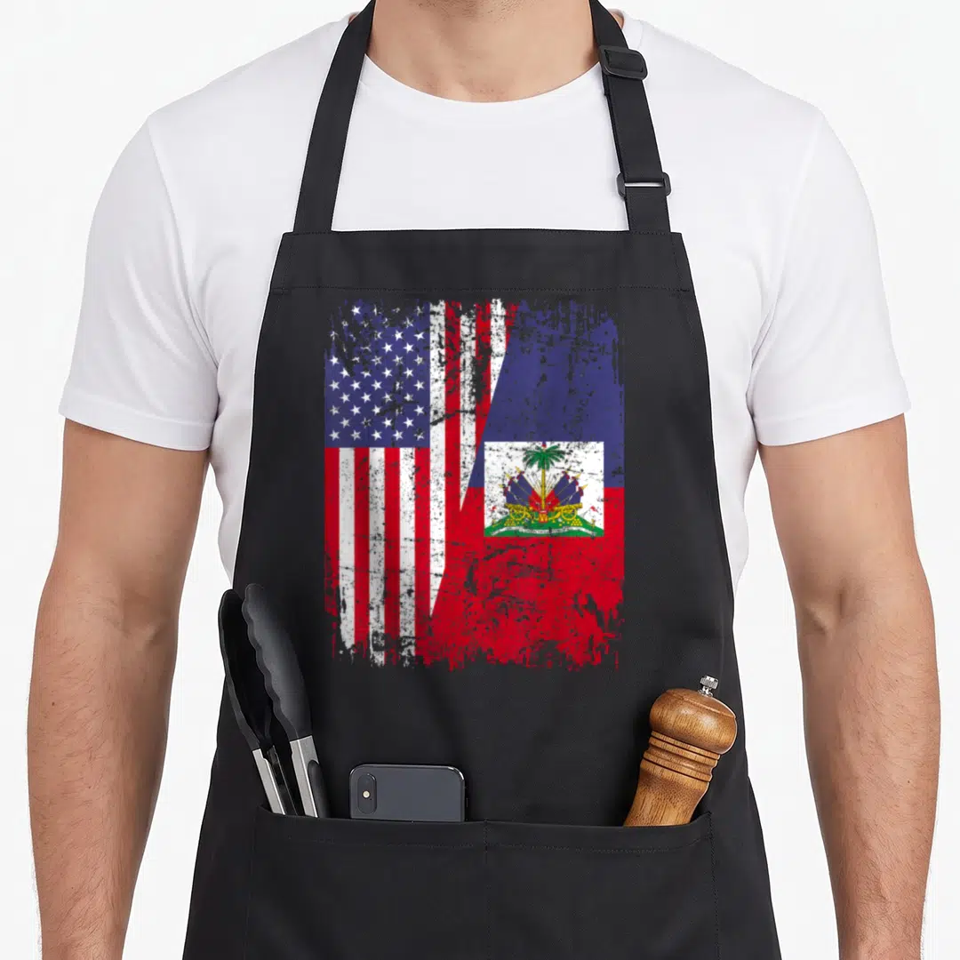 Haitian root american flag apron - Distressed US and Haiti flags split diagonally in red white blue — shown on a black cotton canvas apron against a white background