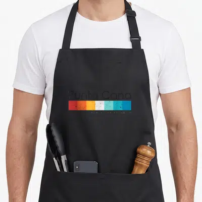 Punta vintage distressed apron - Punta Cana text above six colored rectangles and Dominican Republic label — shown on a black cotton canvas apron against a white background