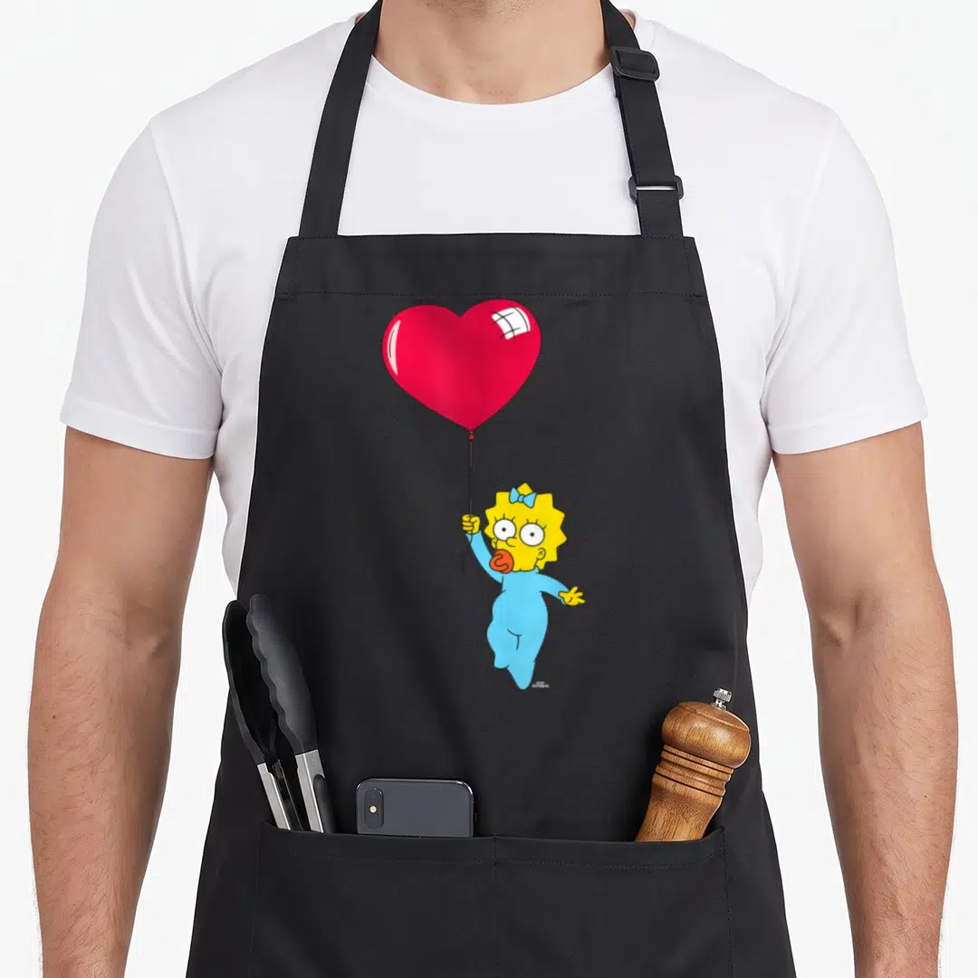 Maggie valentine's day apron - Maggie Simpson in blue onesie holding red heart balloon string, cartoon style — shown on a black cotton canvas apron against a white background