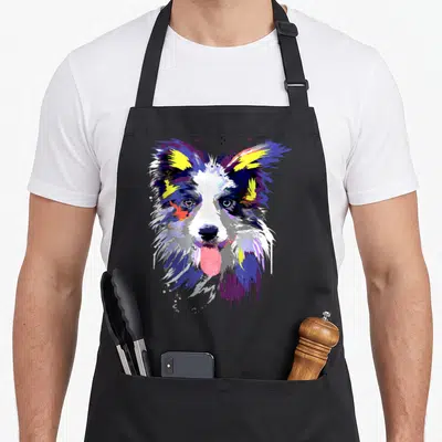 Artistic border collie apron - Multicolored watercolor portrait of a border collie head with paint drips in blue — shown on a black cotton canvas apron against a white background