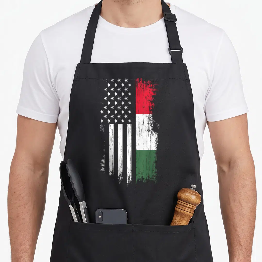 Hungarian american flag apron - Composite flag design with distressed white stars stripes and red white green — shown on a black cotton canvas apron against a white background
