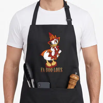 Costume halloween witch apron - Daisy Duck in red and orange witch costume above FA-BOO-LOUS text — shown on a black cotton canvas apron against a white background