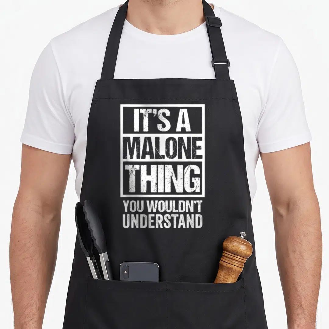 Malone it problems apron - White stacked text It's A Malone Thing You Wouldn't Understand with rectangular border — shown on a black cotton canvas apron against a white background