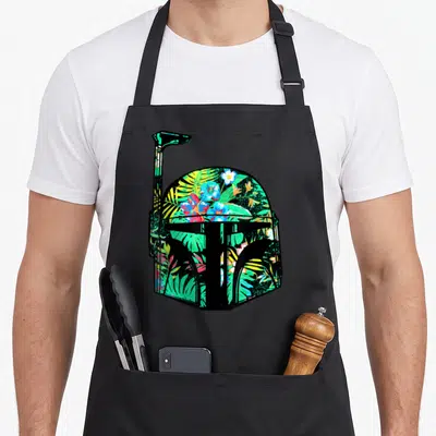 Funny helmet hawaiian apron - Black helmet silhouette filled with red, green, blue, yellow, and black tropical flowers — shown on a black cotton canvas apron against a white background