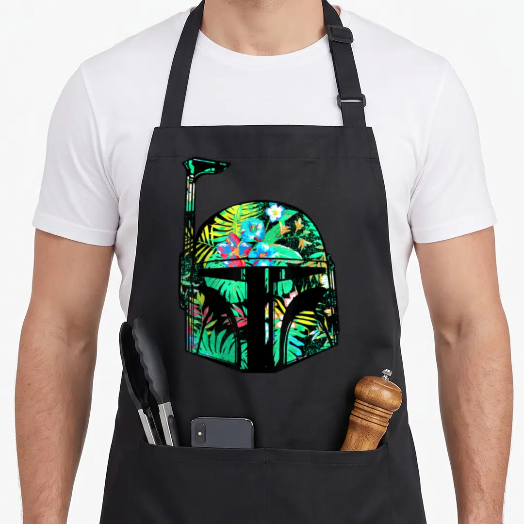 Funny helmet hawaiian apron - Black helmet silhouette filled with red, green, blue, yellow, and black tropical flowers — shown on a black cotton canvas apron against a white background