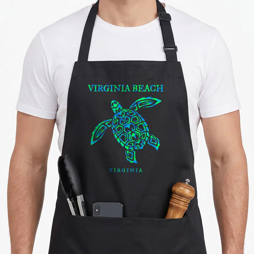 Virginia beach family apron - Blue and green sea turtle graphic between VIRGINIA BEACH and VIRGINIA text — shown on a black cotton canvas apron against a white background
