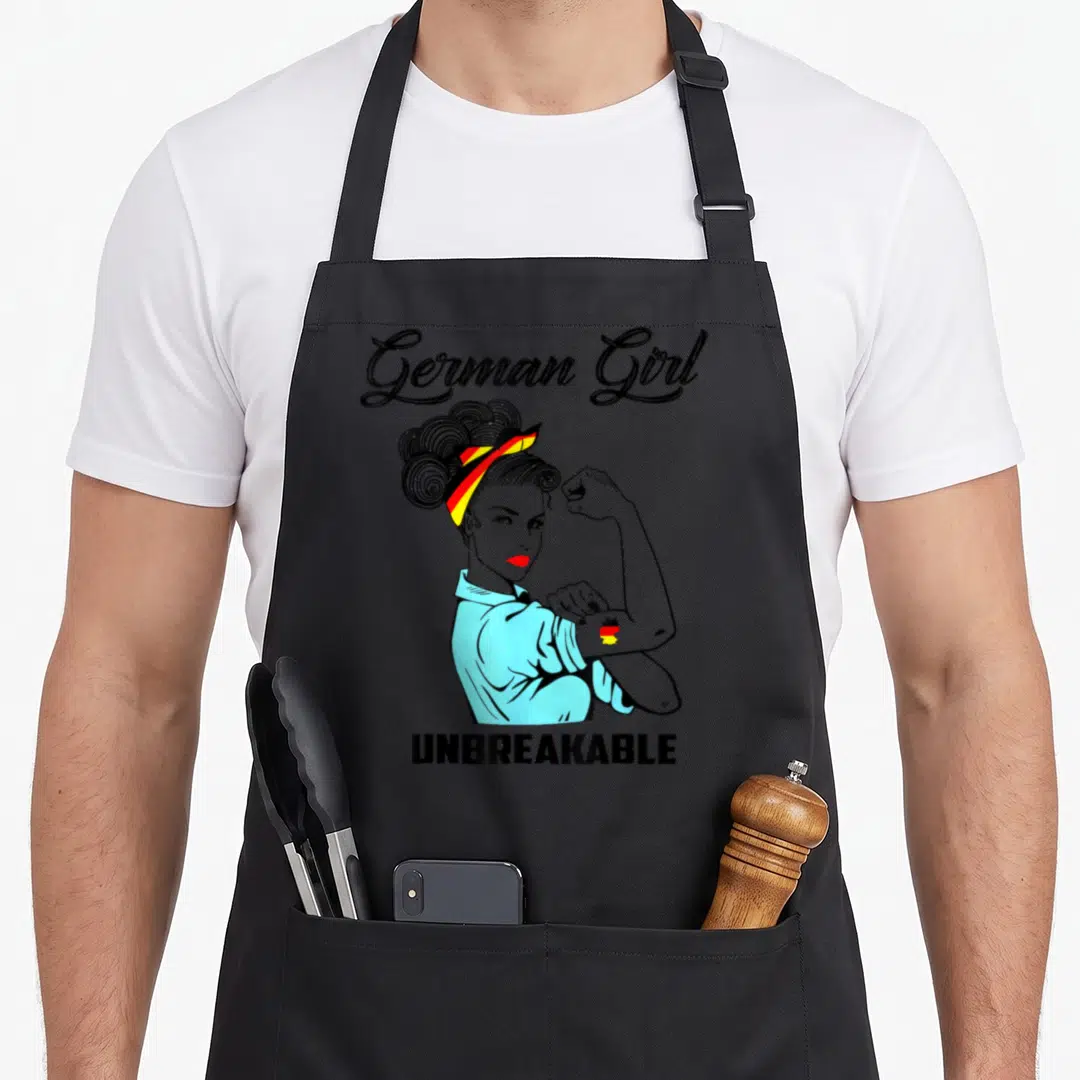 Unbreakable german apron - Line-art woman with German flag headband and UNBREAKABLE text — shown on a black cotton canvas apron against a white background