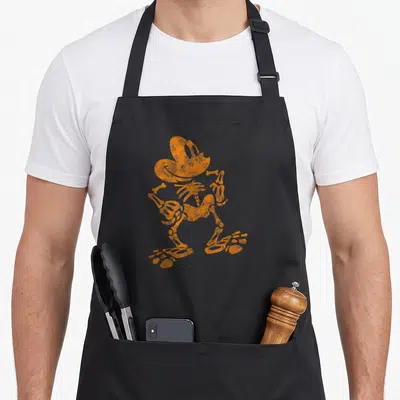 Funny halloween skeleton apron - Single orange distressed skeleton figure standing with hat and bow tie — shown on a black cotton canvas apron against a white background