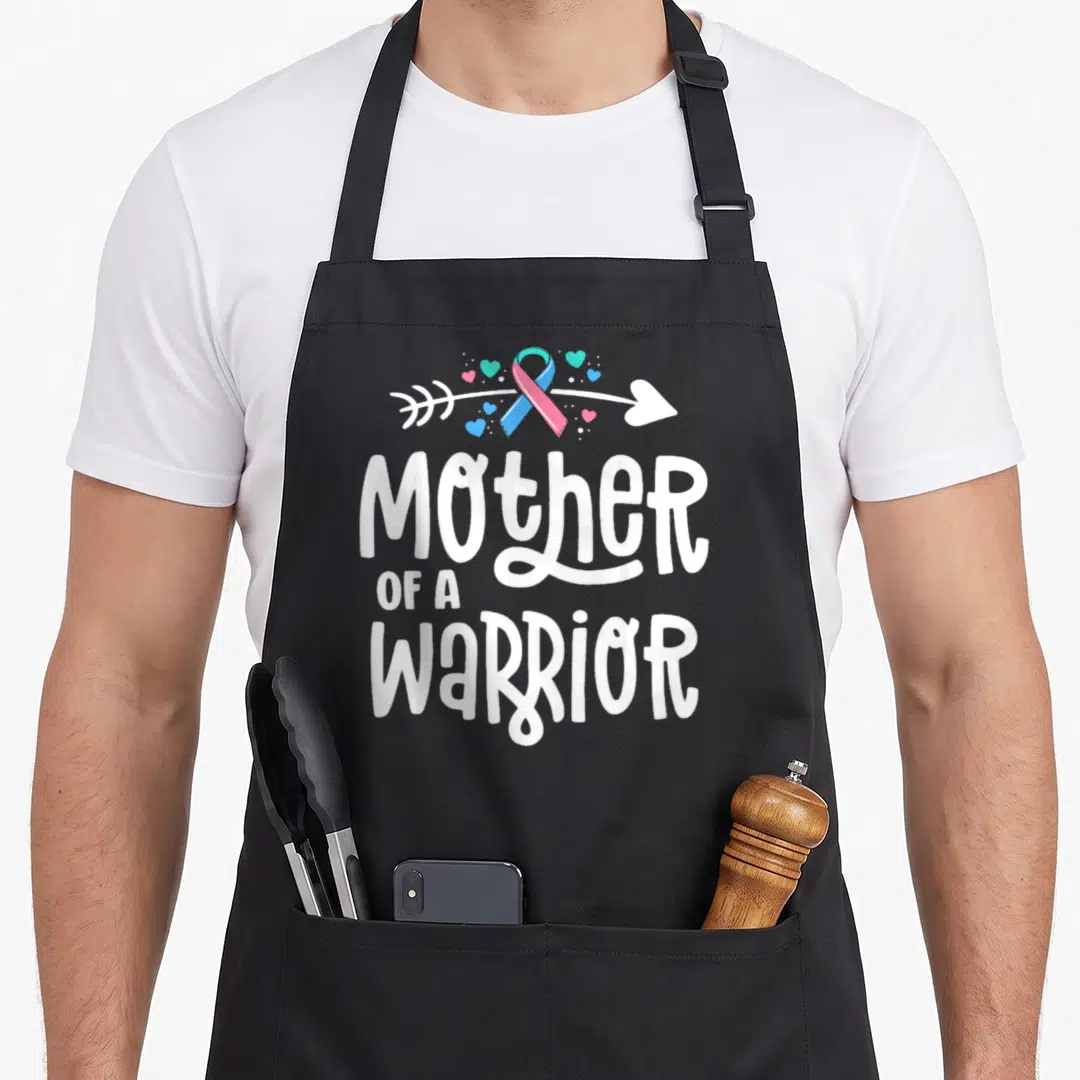 Thyroid mother's apron - Mother of a Warrior text with blue pink ribbon arrow and scattered hearts — shown on a black cotton canvas apron against a white background