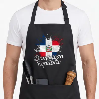 Dominican patriotic apron - Red white blue flag splatter with curved Dominican Republic script text — shown on a black cotton canvas apron against a white background