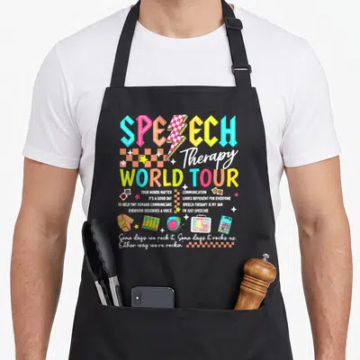Tour my therapy apron - Retro style speech therapy design with colorful text, mixer icon, and AAC devices — shown on a black cotton canvas apron against a white background