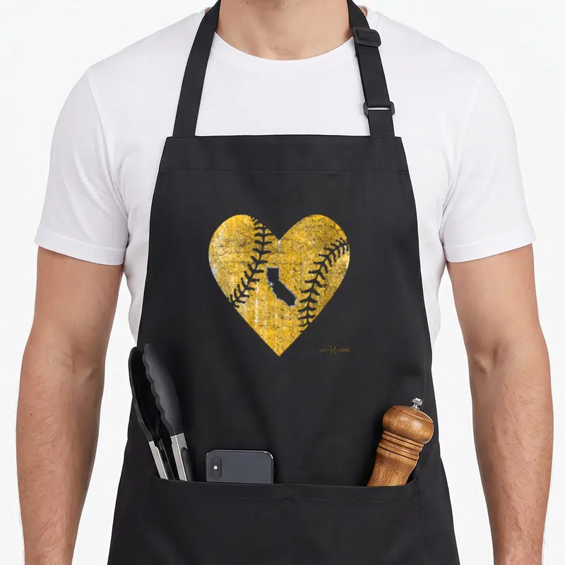 Funny oakland baseball apron - Distressed yellow heart with baseball stitches and grey California outline containing — shown on a black cotton canvas apron against a white background