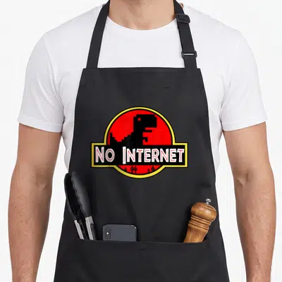 Internet teacher apron - Pixel dinosaur inside red circle with NO INTERNET text and cacti — shown on a black cotton canvas apron against a white background