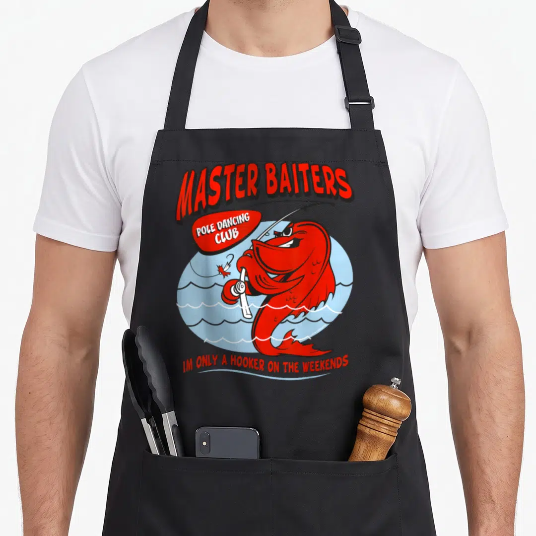 Fishing master apron - Red cartoon fish holding rod inside blue circle with Master Baiters Pole Dancing Club text — shown on a black cotton canvas apron against a white background
