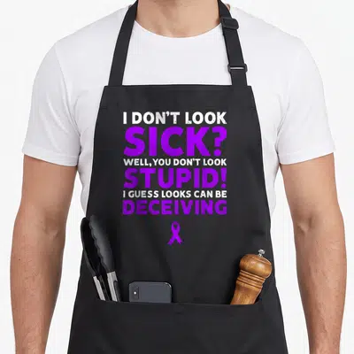Sick cystic fibrosis awareness apron - Purple ribbon and sarcastic text about invisible illness in distressed font — shown on a black cotton canvas apron against a white background