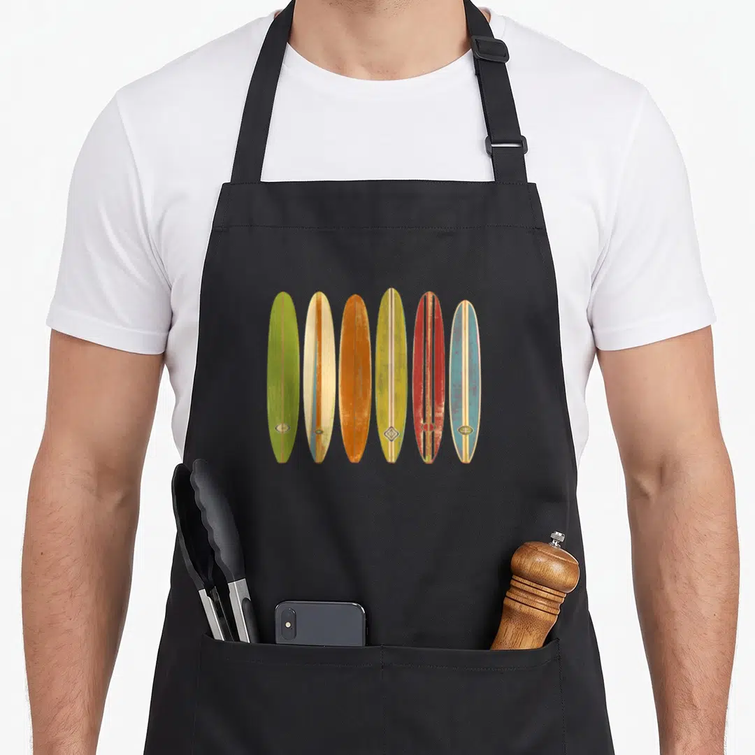 Longboard windsurfing apron - Six vintage surfboards in green yellow orange red and blue with distressed texture — shown on a black cotton canvas apron against a white background
