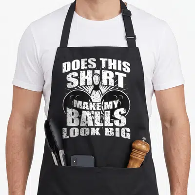 Bowling gag aprons - Distressed white text over bowling pin and two black balls on black background — shown on a black cotton canvas apron against a white background