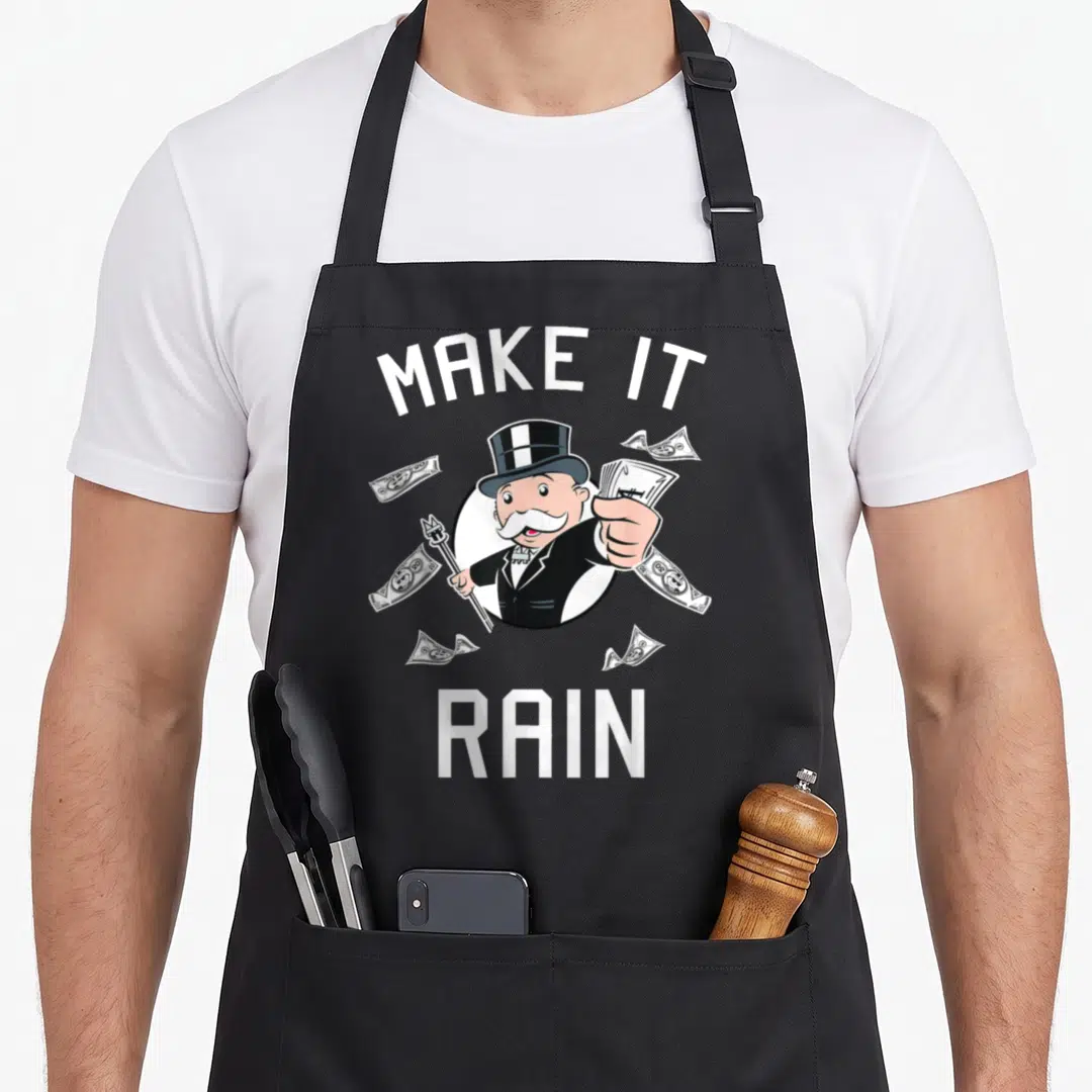 Monopoly rain apron - Cartoon man holding money and cane with arched text on black fabric — shown on a black cotton canvas apron against a white background
