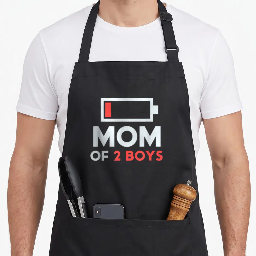 Son mother's day aprons - Low battery icon in white and red above MOM OF 2 BOYS text — shown on a black cotton canvas apron against a white background