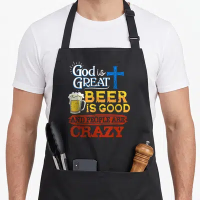Sarcastic beer apron - Stacked text God Is Great Beer Is Good And People Are Crazy with blue cross and beer mug graphics — shown on a black cotton canvas apron against a white background