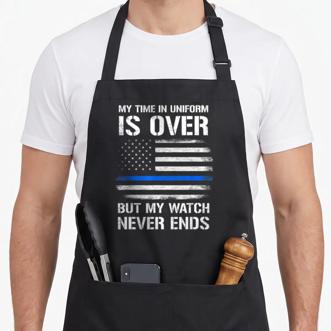 Retired officer police apron - Distressed white and blue flag with one blue stripe and text about watch never ending — shown on a black cotton canvas apron against a white background
