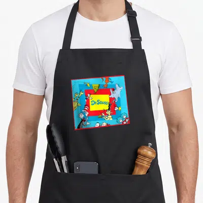 Cute character aprons - Dr. Seuss text in yellow box surrounded by cartoon characters on blue with red border — shown on a black cotton canvas apron against a white background