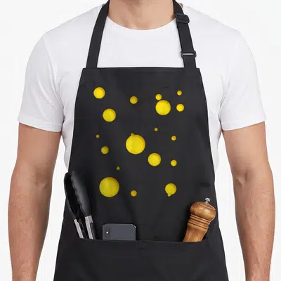 Halloween swiss apron - Scattered yellow circles of varying sizes on grey background — shown on a black cotton canvas apron against a white background