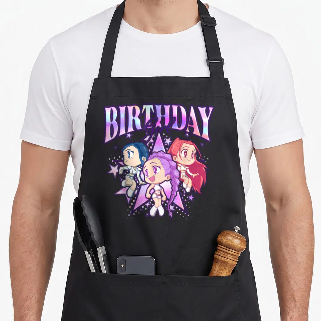 Chibi shot birthday apron - Three chibi anime girls below holographic BIRTHDAY Girl text over a large star in purple — shown on a black cotton canvas apron against a white background