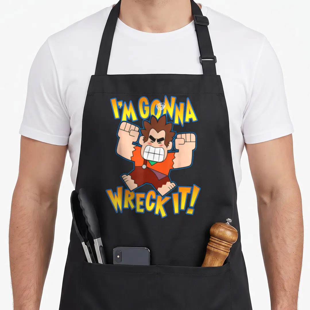 Ralph internet apron - Cartoon character with I'M GONNA WRECK IT! text in yellow orange brown blue — shown on a black cotton canvas apron against a white background