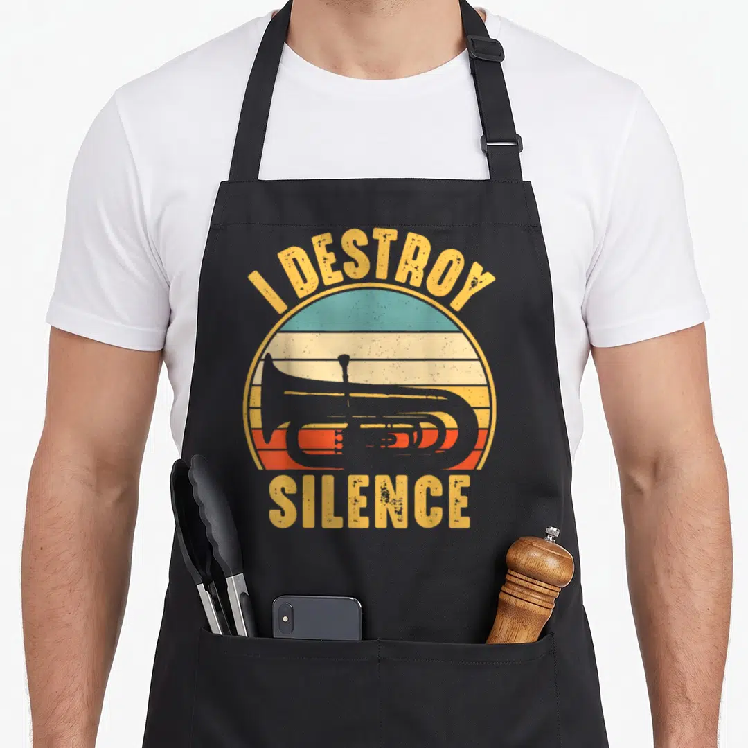 Destroy tuba apron - Grey tuba silhouette inside retro striped sun with text I DESTROY SILENCE — shown on a black cotton canvas apron against a white background