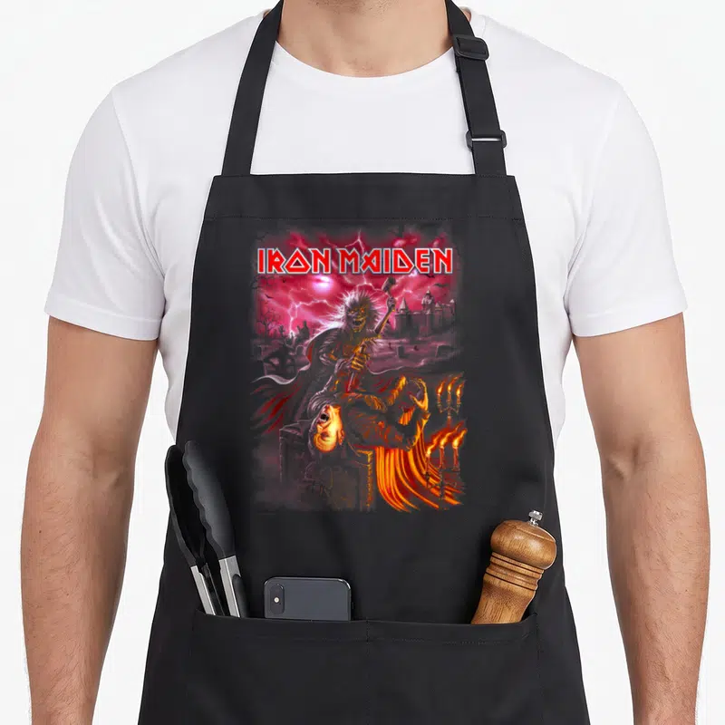 Transylvania camping apron - Iron Maiden text above zombie with hammer, castle, lightning, and candelabra in red — shown on a black cotton canvas apron against a white background