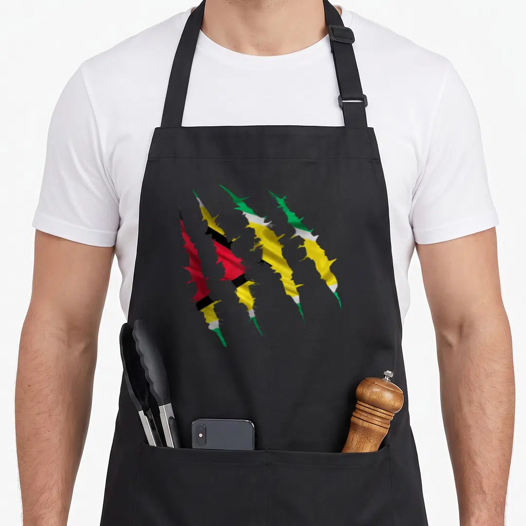 Scratch guyanese apron - Four diagonal claw marks filled with red yellow green and black flag patterns — shown on a black cotton canvas apron against a white background