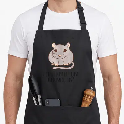 Mouse gerbil owner apron - Cartoon grey gerbil with pink ears sitting above black text I Just Really Like Gerbils Ok — shown on a black cotton canvas apron against a white background