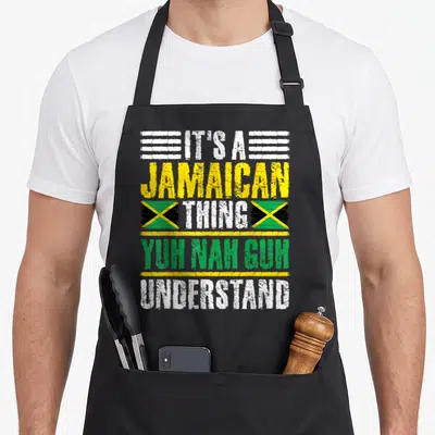 Nah jamaican apron - Stacked Jamaican text with two flags in white yellow green and black distressed print — shown on a black cotton canvas apron against a white background