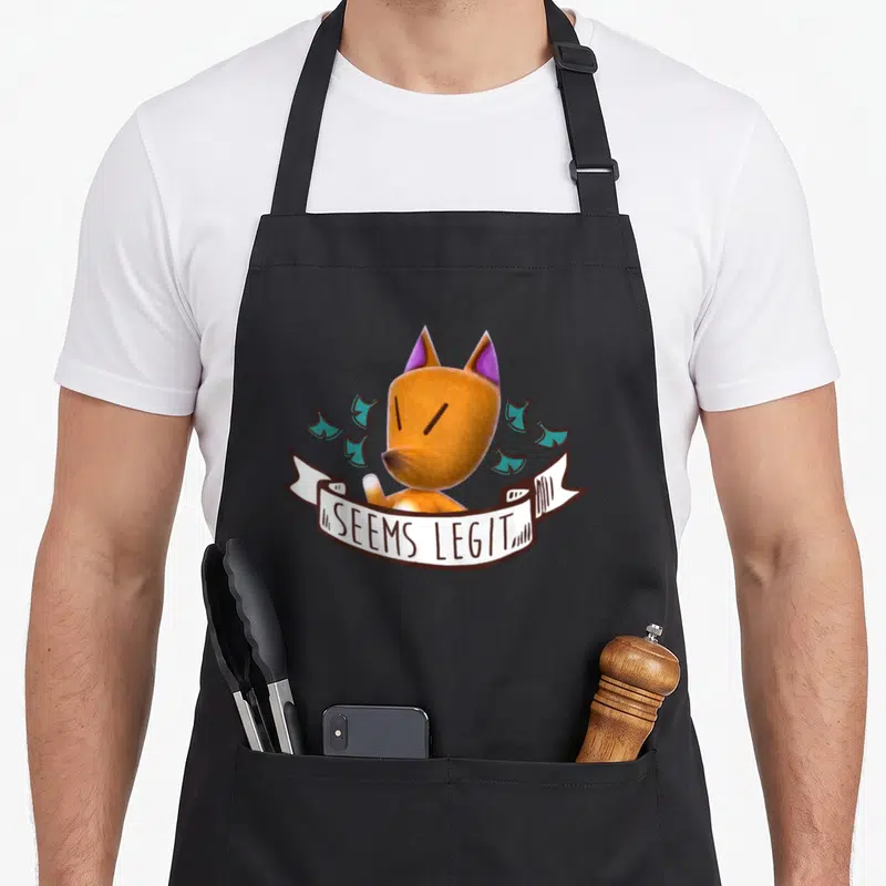 Redd animal apron - Cartoon fox head with white banner reading SEEMS LEGIT and scattered teal shapes — shown on a black cotton canvas apron against a white background