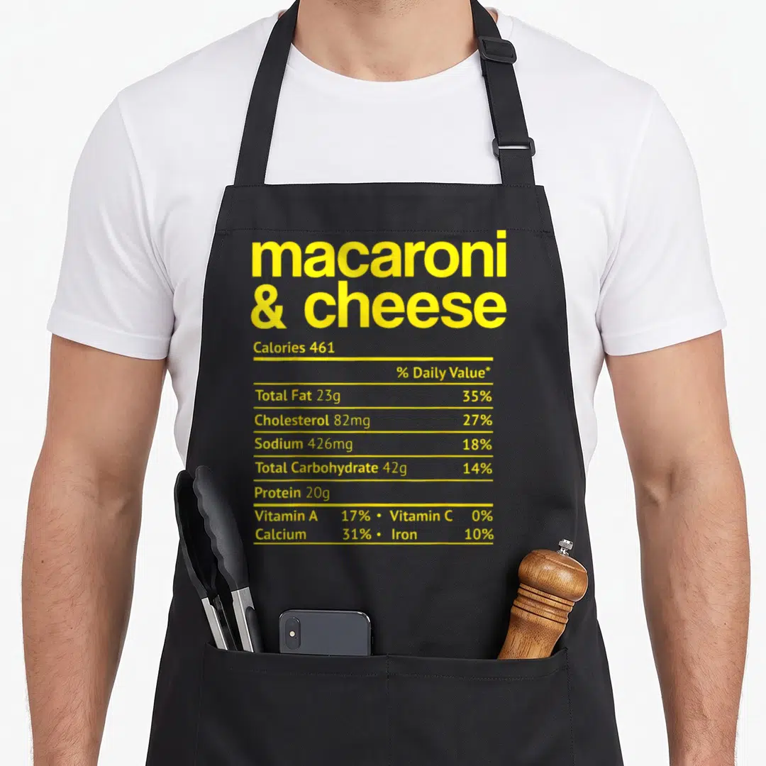 Fact mac apron - Yellow text on grey background listing macaroni cheese nutrition facts including 461 calories and 23g — shown on a black cotton canvas apron against a white background