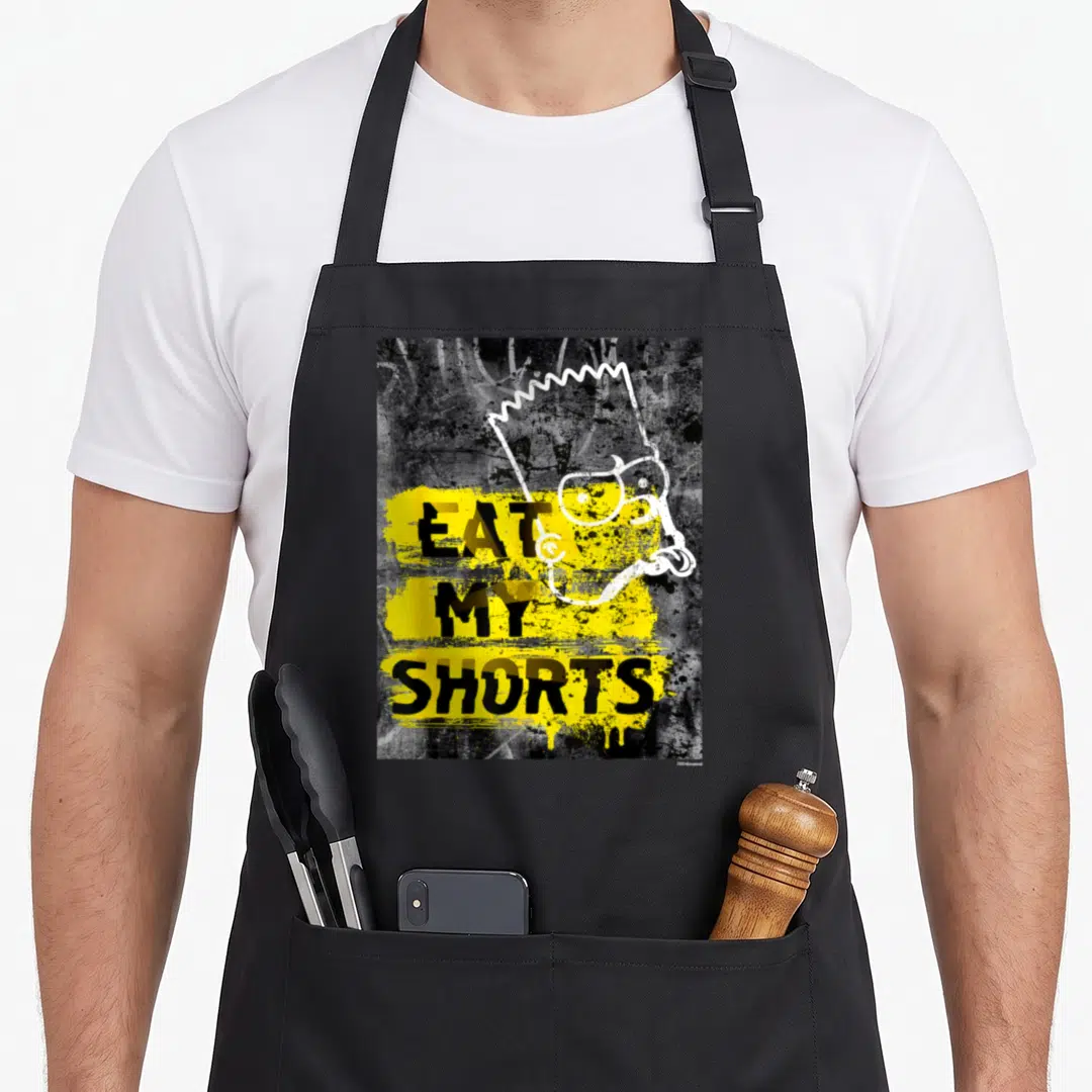 Eat simpson apron - Bart Simpson head outline overlapping stacked Eat My Shorts text on yellow splatter — shown on a black cotton canvas apron against a white background