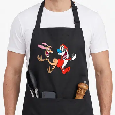 Ren bump apron - Two cartoon characters standing side-by-side facing each other and laughing in red, tan, blue, and pink — shown on a black cotton canvas apron against a white background