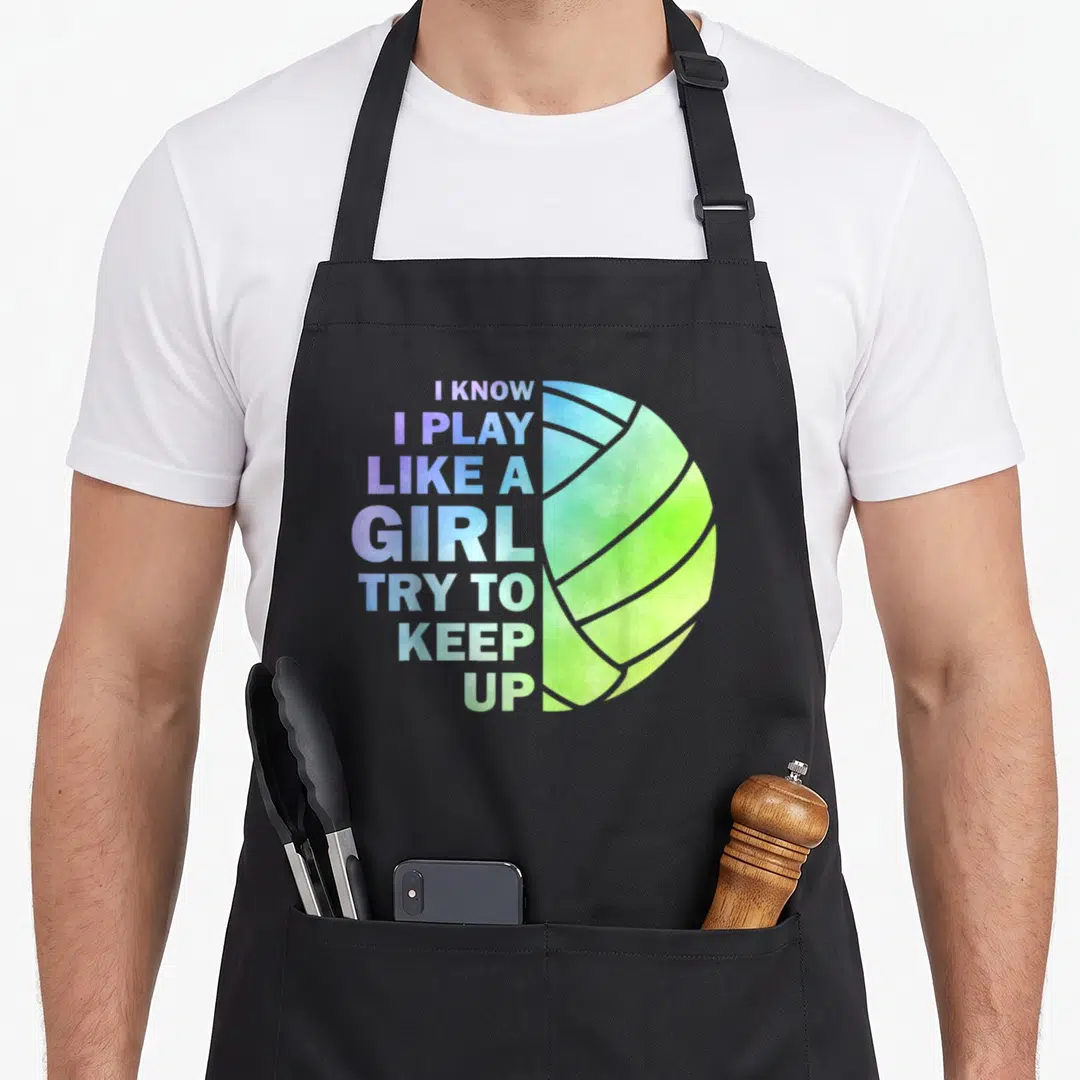 Volleyball sports team aprons - Stacked rainbow gradient text reading I KNOW I PLAY LIKE A GIRL TRY TO KEEP UP beside — shown on a black cotton canvas apron against a white background