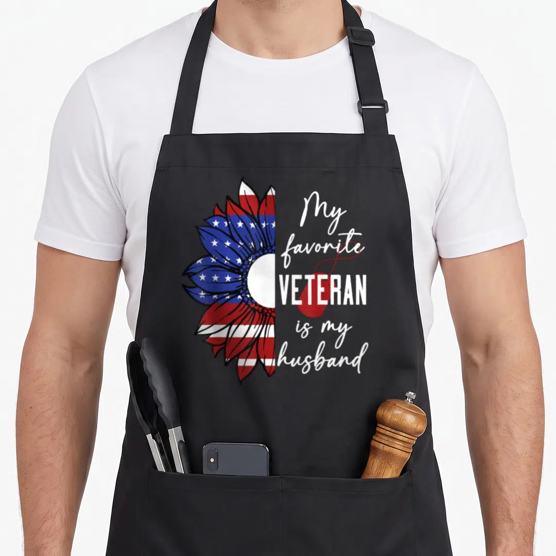 Sunflower best husband apron - Patriotic sunflower half-print with My favorite VETERAN is my husband text and red dog — shown on a black cotton canvas apron against a white background