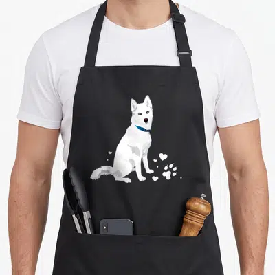 Sweet husky apron - White cartoon dog sitting with blue collar and white hearts paw print — shown on a black cotton canvas apron against a white background