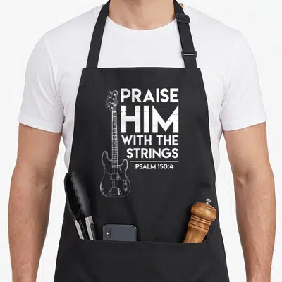 Praise christian apron - White distressed bass guitar and PRAISE HIM WITH THE STRINGS PSALM 150:4 text — shown on a black cotton canvas apron against a white background