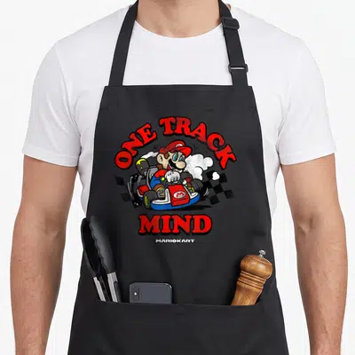 Funny mind track apron - Mario in go-kart with ONE TRACK MIND text and two checkered flags — shown on a black cotton canvas apron against a white background