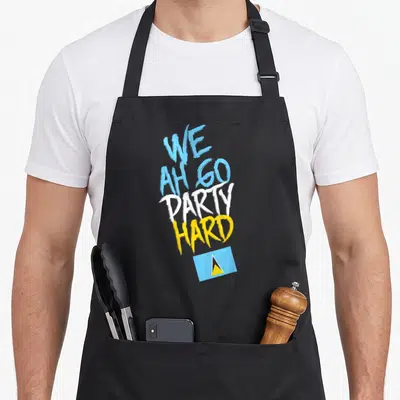 Hard saint lucia apron - Stacked We Ah Go Party Hard text in blue white and yellow above a small rectangular flag — shown on a black cotton canvas apron against a white background