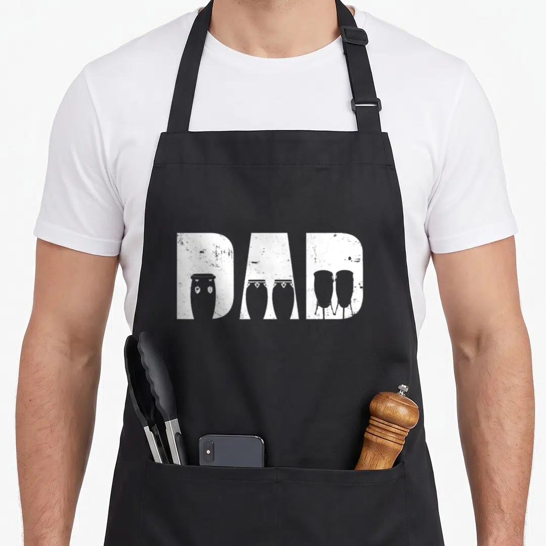 Conga pigeon mom apron - DAD text with white drum silhouettes inside distressed block letters — shown on a black cotton canvas apron against a white background