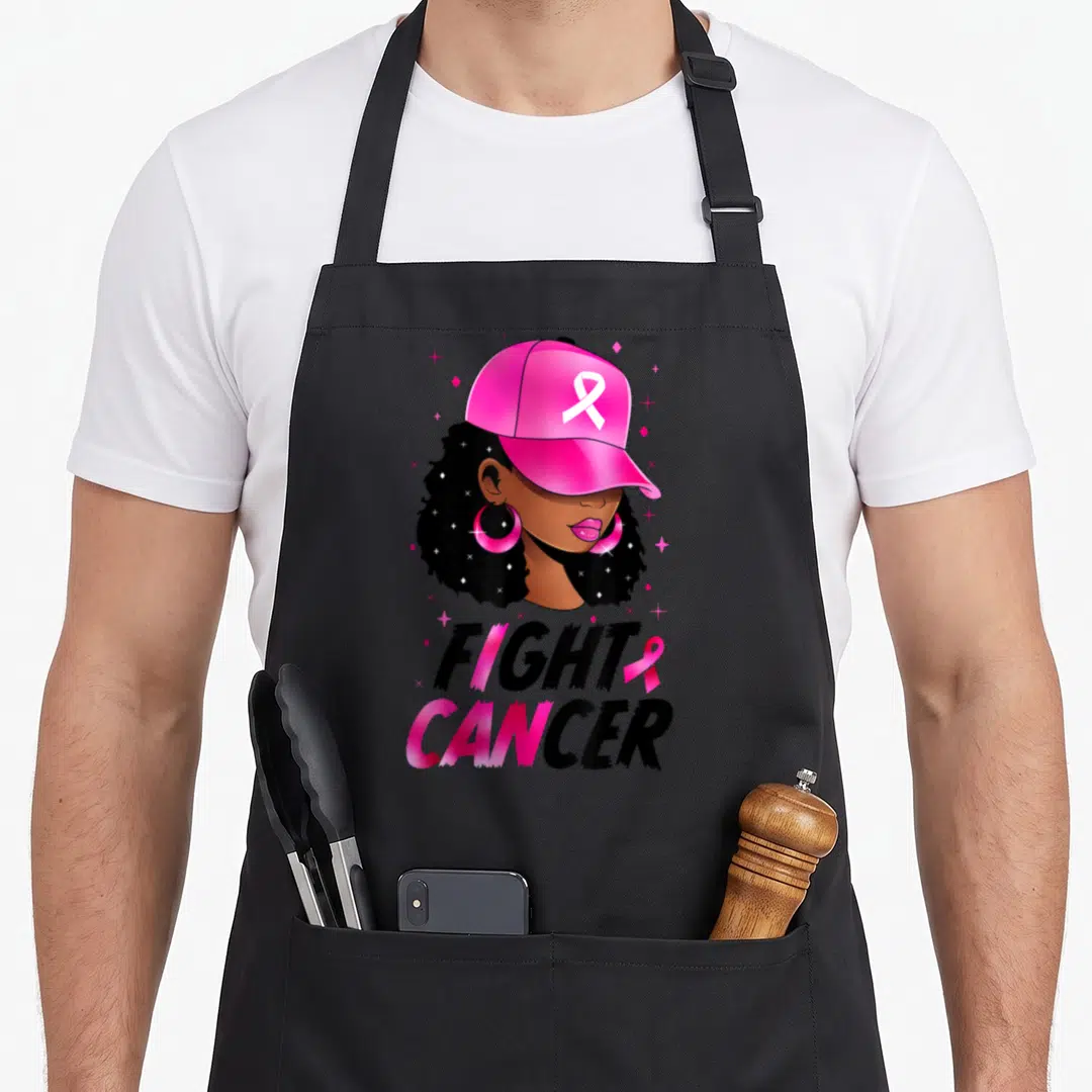 Breast cancer ribbon apron - Woman in pink cap with FIGHT CANCER text and ribbons — shown on a black cotton canvas apron against a white background